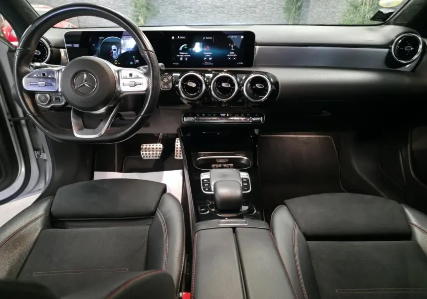 Vue intérieure avant de la Mercedes Classe A A 200 d AMG Line 2019 avec tableau de bord numérique et sièges sport noirs.