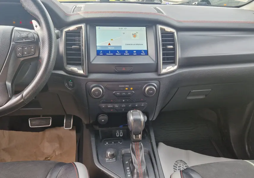 Vue intérieure du tableau de bord et console centrale du Ford Ranger Raptor 2022 avec volant cuir et écran tactile.