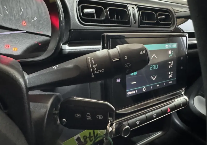 Vue rapprochée de l'intérieur de la Citroën C3 bleue 2018, montrant la commande d'essuie-glace et l'écran tactile central.