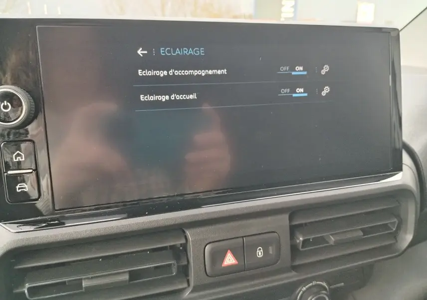 Écran tactile central du Peugeot Partner Fourgon 2025 affichant les réglages d’éclairage, avec les aérateurs en dessous.
