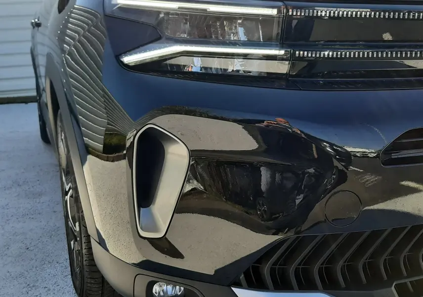 Gros plan sur l'avant gauche du Citroën C5 Aircross noir Perla Nera, mettant en valeur les phares LED et la calandre moderne.