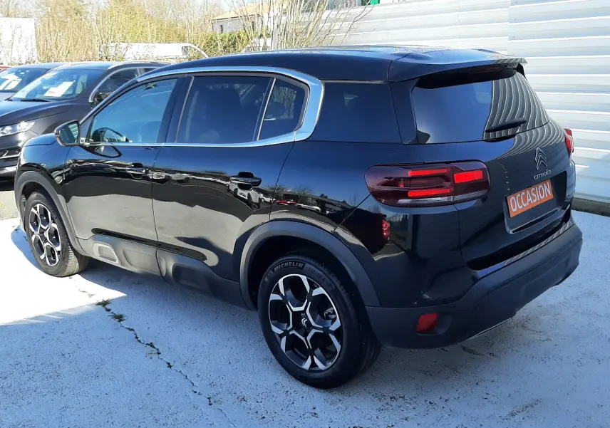 Vue 3/4 arrière droite d'un Citroën C5 Aircross noir Perla Nera avec jantes bi-ton et feux arrière LED.