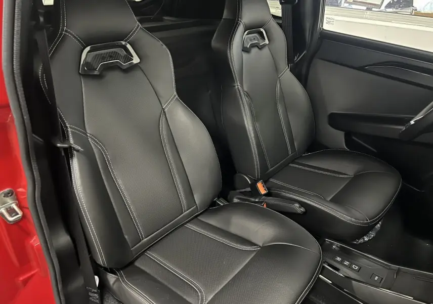 Vue intérieure côté droit montrant les sièges noirs en cuir du LIGIER JS50 BEV 8KWH ELITE rouge 2025 avec boîte auto.