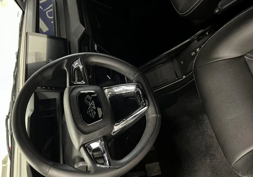 Vue intérieure côté conducteur du tableau de bord noir et volant cuir du Ligier JS50 BEV 8KWH ELITE 2025.