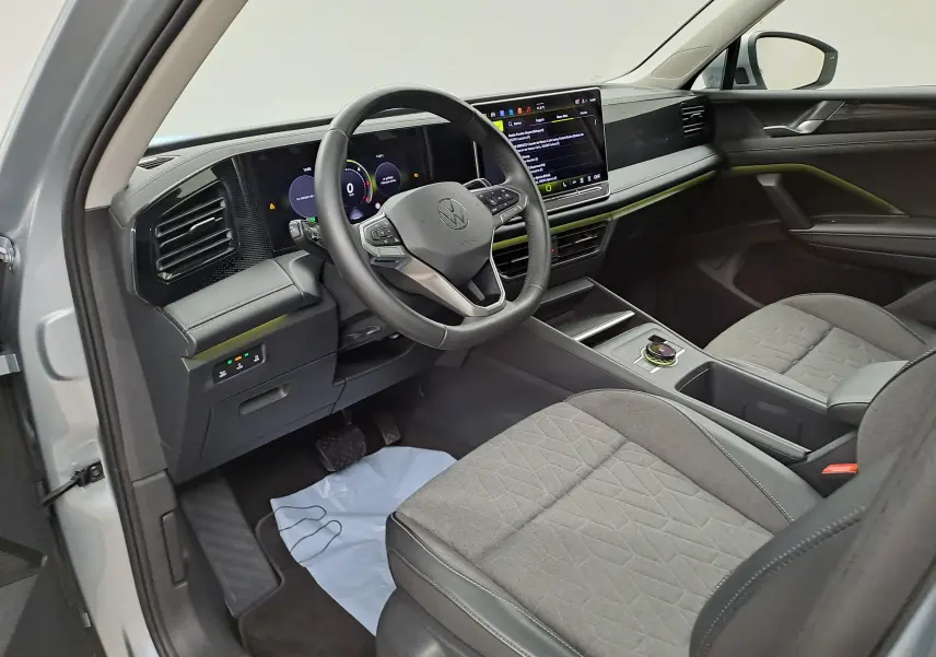Vue intérieure côté conducteur du Volkswagen Tiguan 2025 avec tableau de bord numérique et volant multifonction noir.