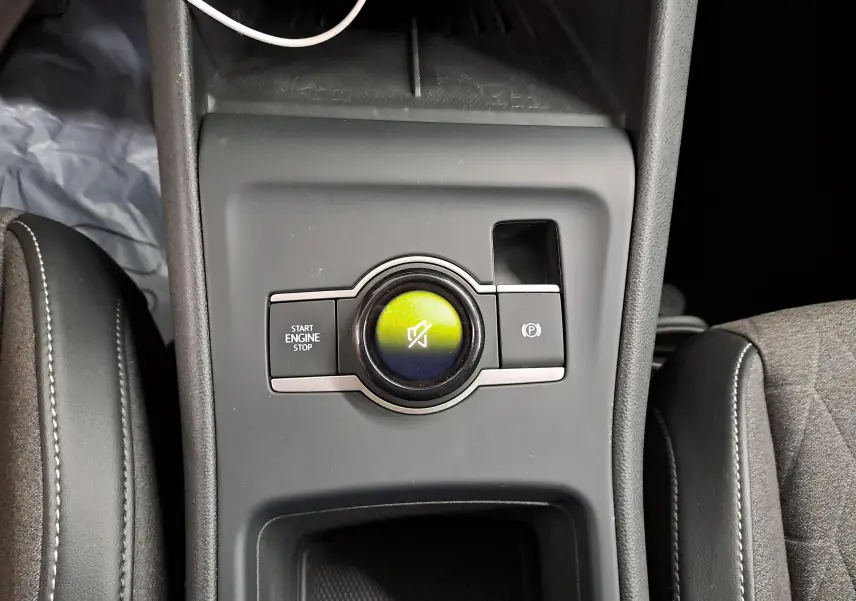 Vue plongeante sur la console centrale du Volkswagen Tiguan 2025, avec bouton start/stop et frein à main électronique.