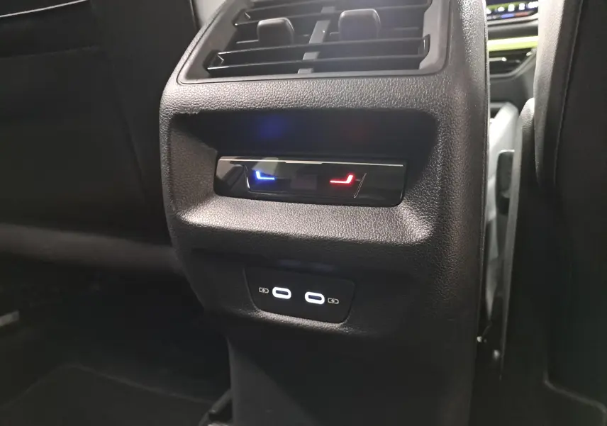 Vue rapprochée de la console arrière du Volkswagen Tiguan 2025, avec commandes de climatisation et ports USB visibles.