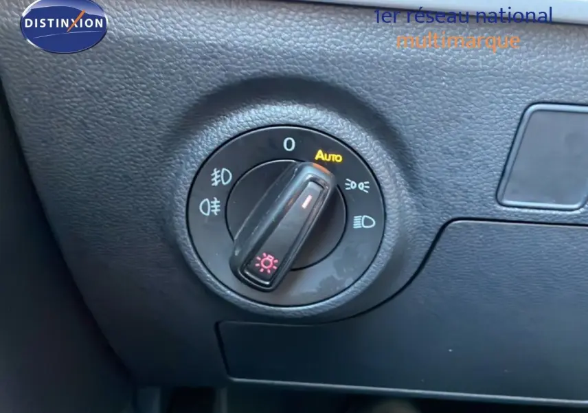 Gros plan sur le sélecteur des phares du tableau de bord d’un SEAT Arona blanc toit gris, version 2025.