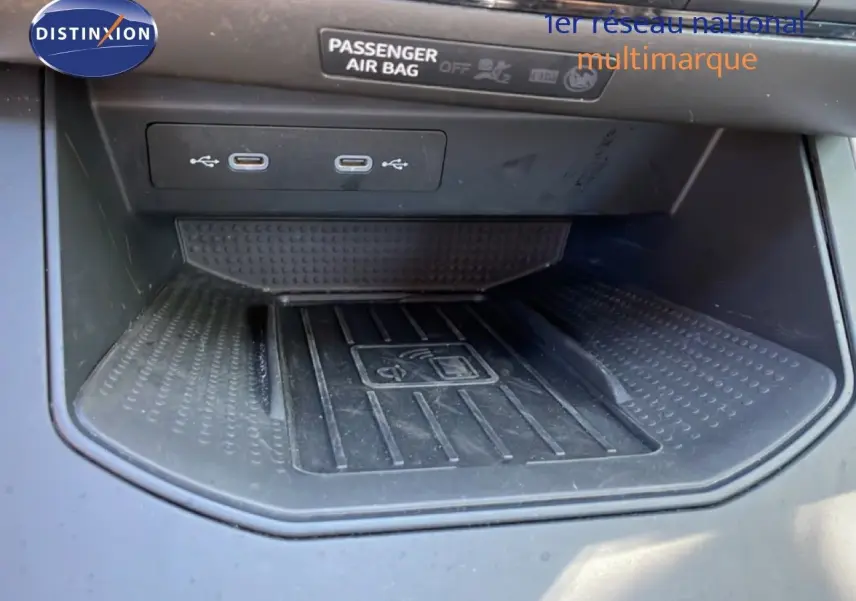 Gros plan sur la zone de recharge sans fil et ports USB du SEAT Arona 2025, intérieur noir, console centrale.