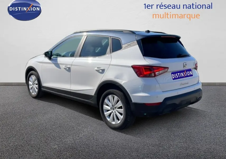 SEAT Arona blanc avec toit gris, vue 3/4 arrière droit, mettant en valeur ses feux arrière et jantes alliage.