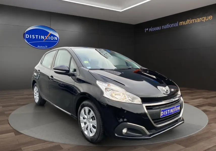 Peugeot 208 Affaire noire vue en 3/4 avant droit, avec phares allumés et jantes argentées en showroom.