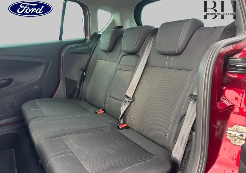 Vue intérieure sur la banquette arrière noire du Ford B-MAX rouge Premium avec porte latérale coulissante ouverte.