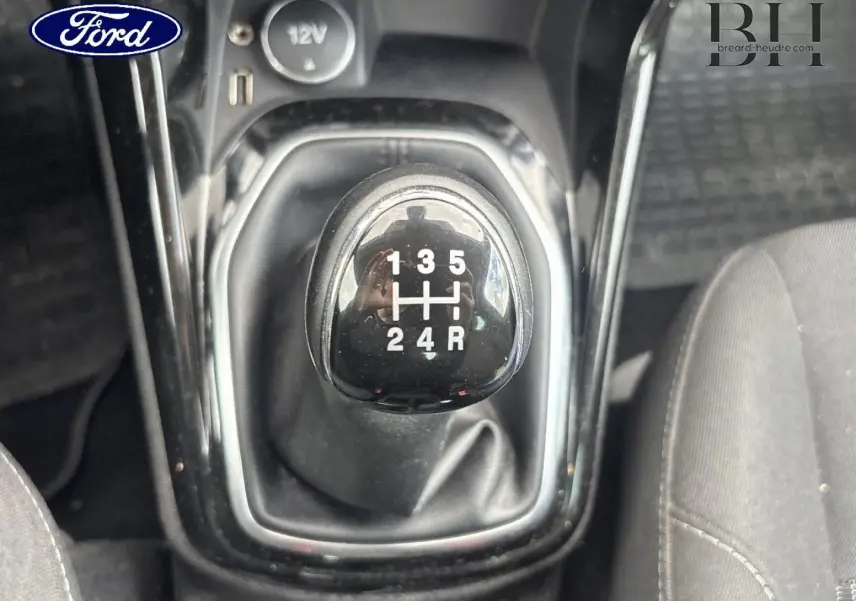 Le levier de vitesses manuel noir de la Ford B-MAX 2017, vue rapprochée de dessus avec sièges gris visibles.