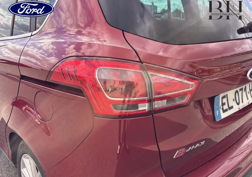 Vue 3/4 arrière droite d'une Ford B-MAX 2017 en rouge Premium Candy avec feux arrière et jantes alu visibles.