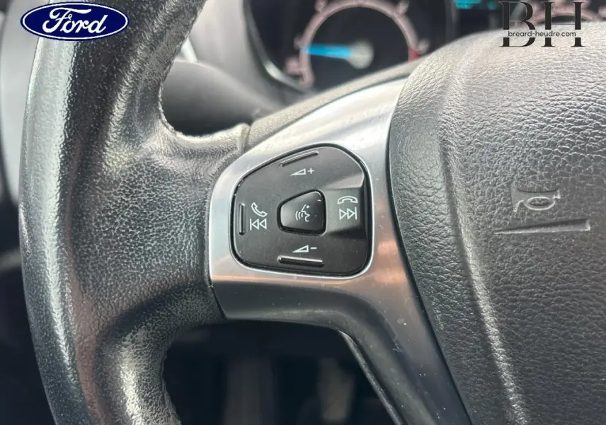 Gros plan sur le volant en cuir noir de la Ford B-MAX avec commandes audio et vocales intégrées.