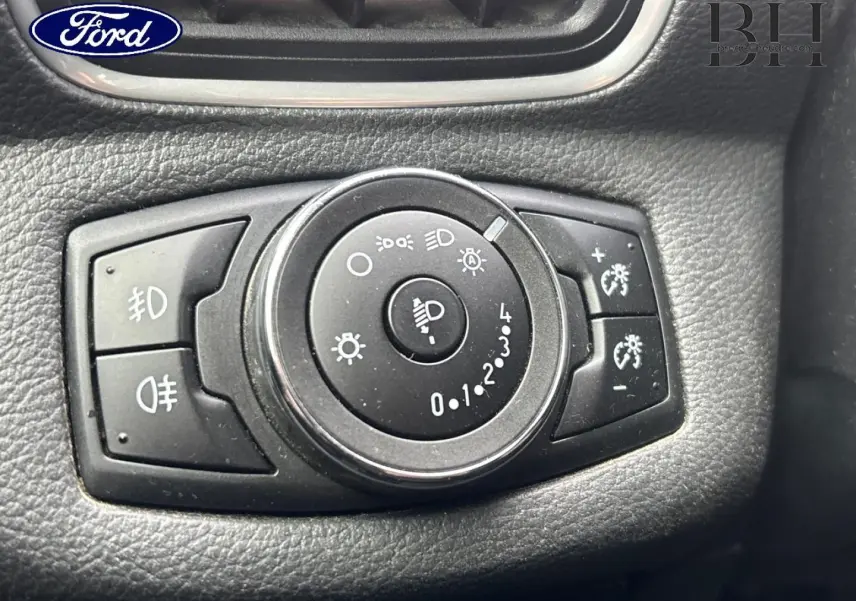Gros plan sur la molette de réglage des phares du Ford B-MAX 2017, entourée de boutons noirs sur tableau de bord noir.