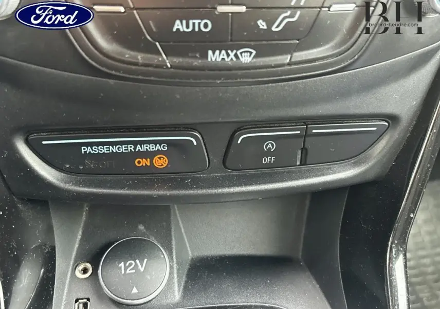 Détail intérieur du Ford B-MAX 2017 montrant la console centrale avec prise 12V et voyants airbag et arrêt auto du moteur.
