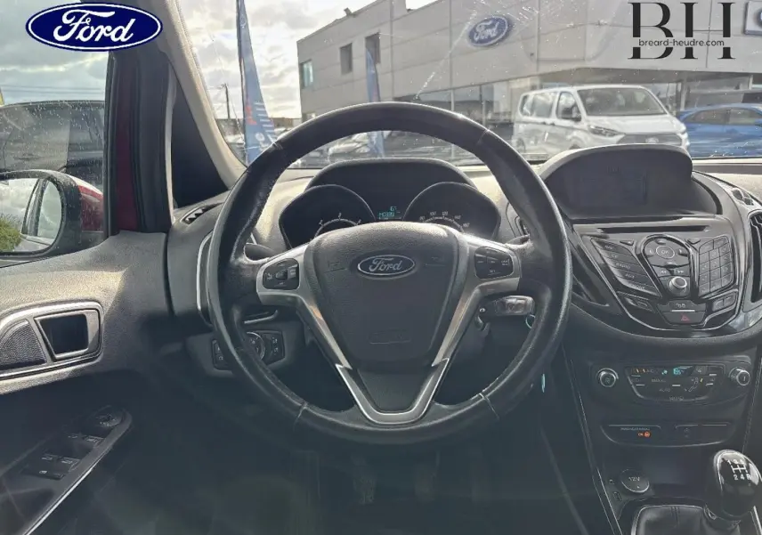 Vue intérieure centrée sur le volant cuir multifonction et la console centrale du Ford B-MAX Premium Rouge Candy 2017.