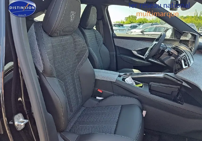 Vue intérieure côté conducteur du Peugeot 3008 2025, sièges tissu et cuir noir avec logo Peugeot brodé sur appuie-tête.