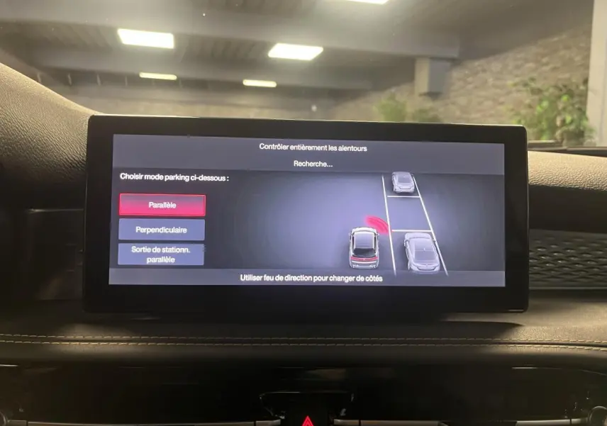 Écran central de l'Alfa Romeo Tonale 2024 montrant l'assistance au stationnement avec vue sur le tableau de bord noir.