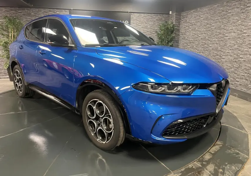 Alfa Romeo Tonale bleu en 3/4 avant droit, avec jantes alliage 18 pouces et calandre noire distinctive.