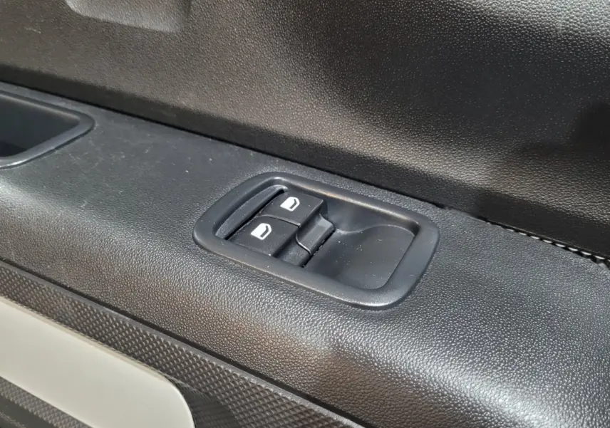 Gros plan sur les commandes de verrouillage des portes côté conducteur de la Citroën C3 beige 2022.