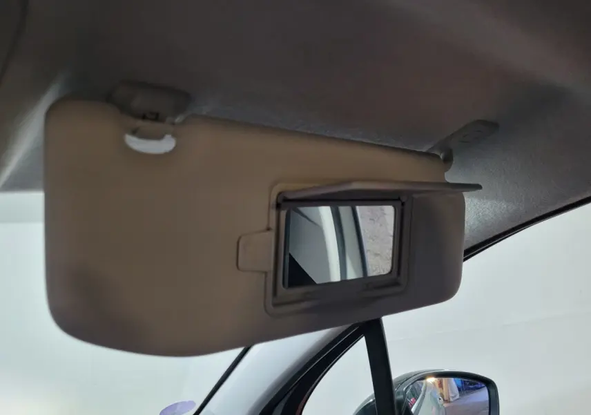 Miroir de courtoisie sur pare-soleil côté conducteur d'une Citroën C3 beige, intérieur vue rapprochée.