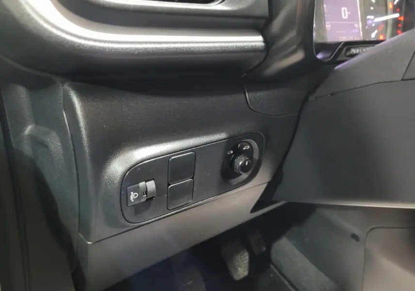 Vue intérieure côté gauche du tableau de bord de la Citroën C3 beige 2022 avec commandes des phares et réglage hauteur.