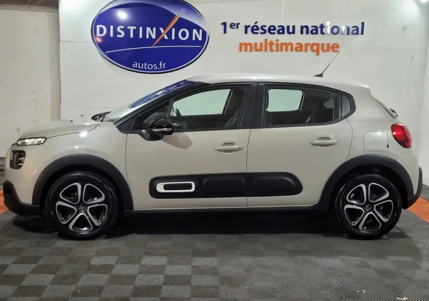Profil côté gauche d'une Citroën C3 beige 2022 avec protections latérales noires et jantes alliage distinctives.