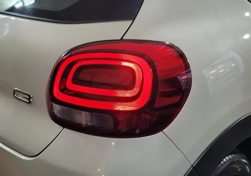 Gros plan sur le feu arrière droit rouge d'une Citroën C3 beige 2022 avec logo C3 visible sur la carrosserie.