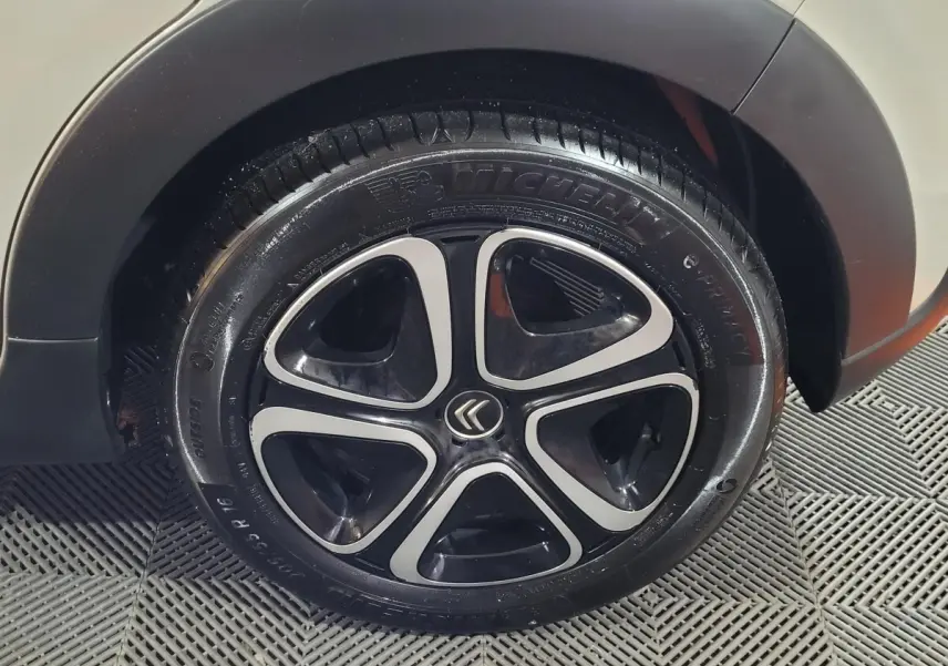 Gros plan sur la roue arrière droite beige d'une Citroën C3 avec jante noire et argentée au design moderne.