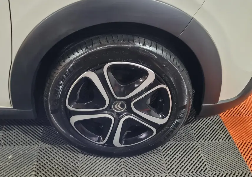 Gros plan sur la roue avant gauche beige d'une Citroën C3 2022 avec jante noire et argentée au design moderne.