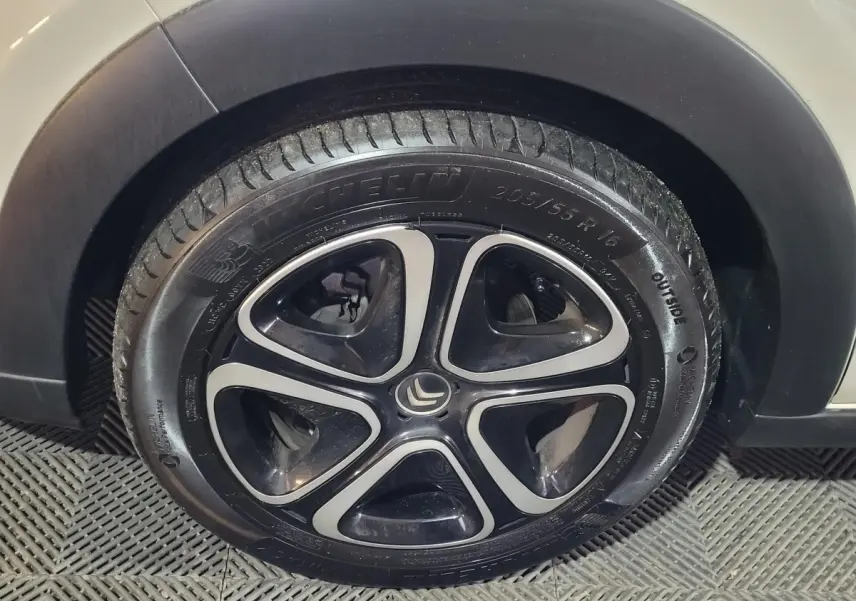 Gros plan sur la roue avant droite de la Citroën C3 beige 2022 avec jante noire et argentée au design moderne.