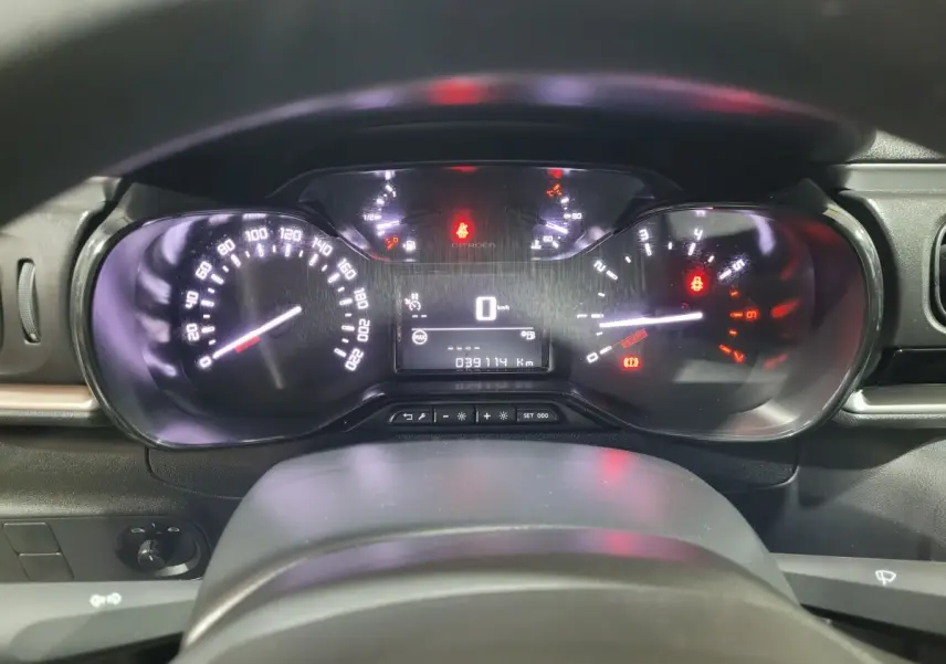 Vue rapprochée du tableau de bord numérique de la Citroën C3 beige, affichant la vitesse à 0 km/h et le compteur kilométrique.