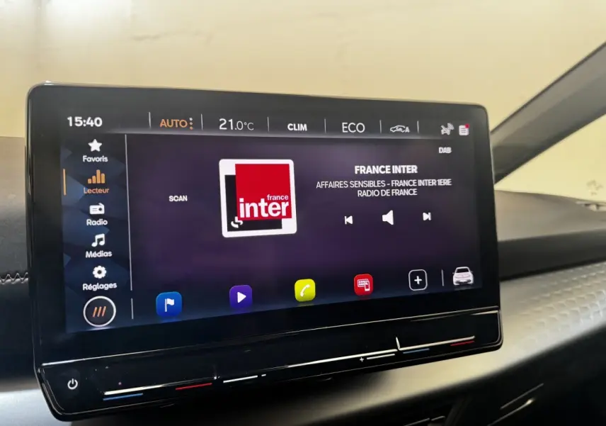 Écran tactile central de 12 pouces du tableau de bord d'une CUPRA Born 230ch gris foncé, affichant la radio France Inter.