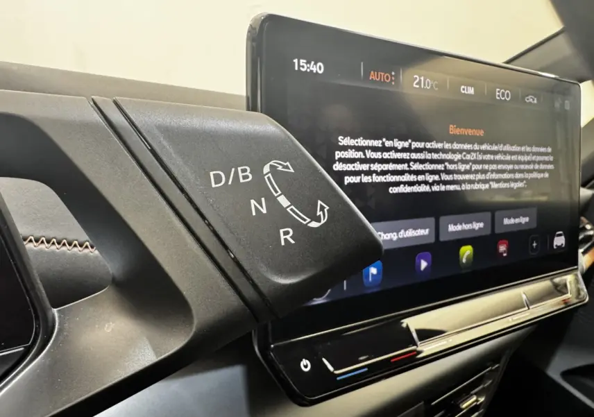 Gros plan sur la commande de boîte automatique et l'écran tactile central affichant les réglages climatiques du CUPRA Born gris foncé.