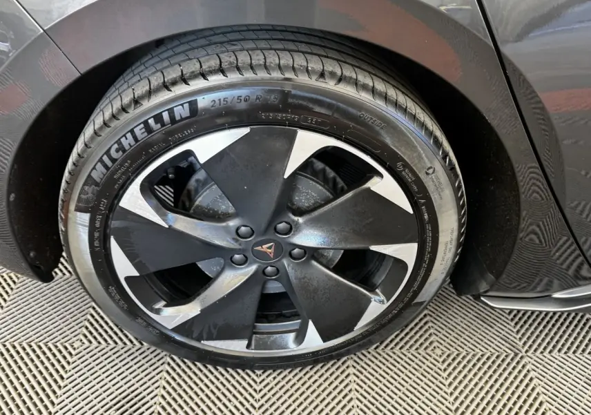 Gros plan sur la roue avant droite d'une CUPRA BORN gris foncé avec jante noire et argentée au design moderne.