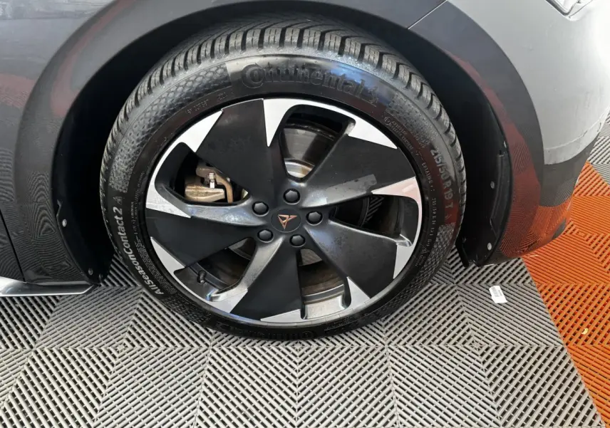 Gros plan sur la roue avant gauche gris foncé d'une CUPRA BORN 230ch, jante noire et argentée distinctive.