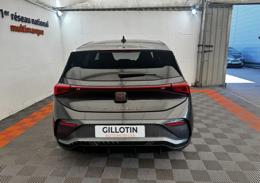 Vue arrière d'une CUPRA BORN gris foncé 2023 avec feux LED reliés et logo CUPRA lumineux au centre.