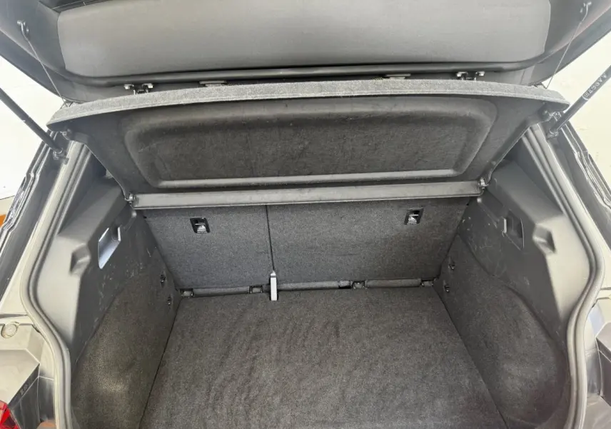 Coffre ouvert vu de l'arrière d'une CUPRA Born gris foncé, montrant l'espace de chargement et la tablette de séparation.