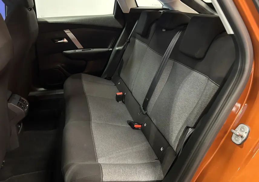 Vue intérieure côté droit des sièges arrière gris et noirs d'une Citroën C4 orange 2021 avec porte ouverte.