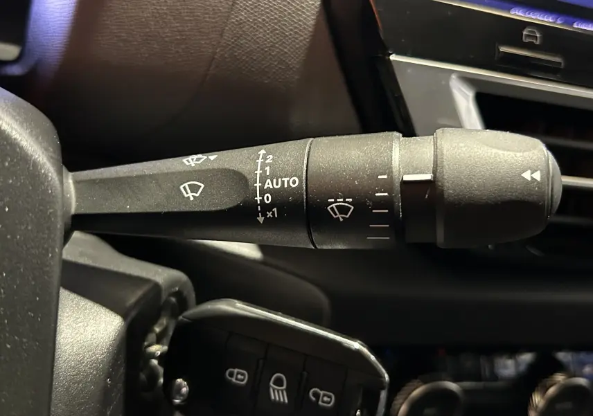 Gros plan sur la commande d'essuie-glace et la clé de contact dans l'habitacle d'une Citroën C4 orange PureTech 2021.