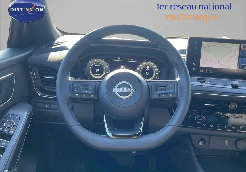 Vue intérieure centrée sur le volant Nissan du Qashqai 2025 avec tableau de bord numérique et écran tactile de navigation.