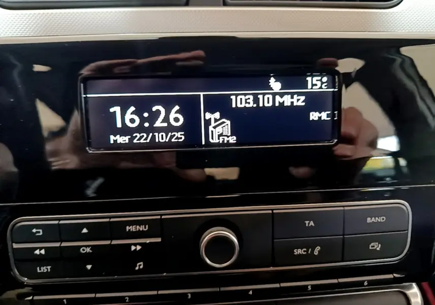 Affichage central de la radio et de l'heure sur le tableau de bord noir brillant d'une Citroën C3 PureTech 68 BVM Live.