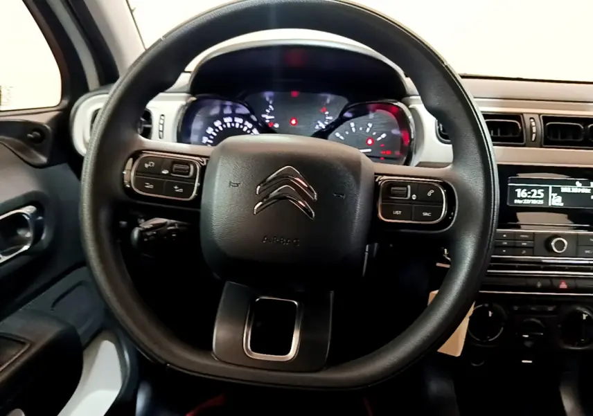 Vue intérieure centrée sur le volant noir de la Citroën C3 PureTech 68 BVM Live avec tableau de bord et console visibles.