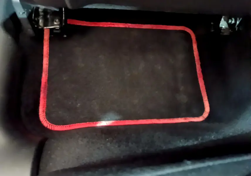 Gros plan sur le tapis de sol noir avec bordure rouge dans l'habitacle d'une Citroën C3 blanche 2018.