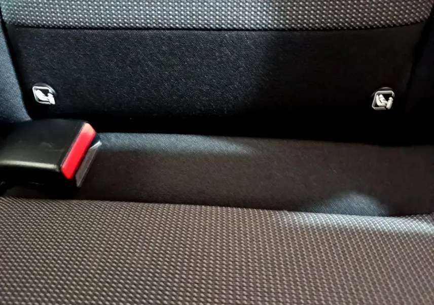 Gros plan sur la banquette arrière noire de la Citroën C3 avec attaches Isofix visibles et boucle de ceinture rouge.