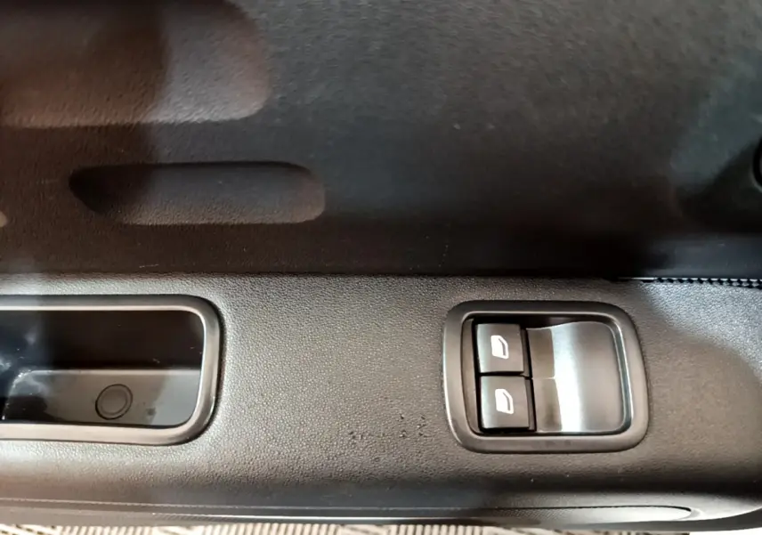 Gros plan sur les commandes de lève-vitres côté conducteur d'une Citroën C3 blanche PureTech 2018.