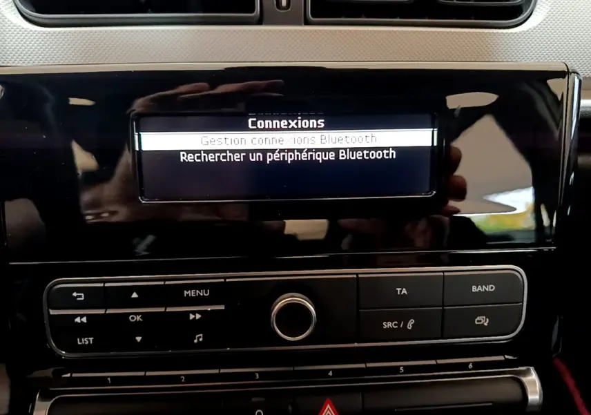 Détail de la console centrale noire de la Citroën C3 blanche 2018, affichant le menu Bluetooth sur l'écran.