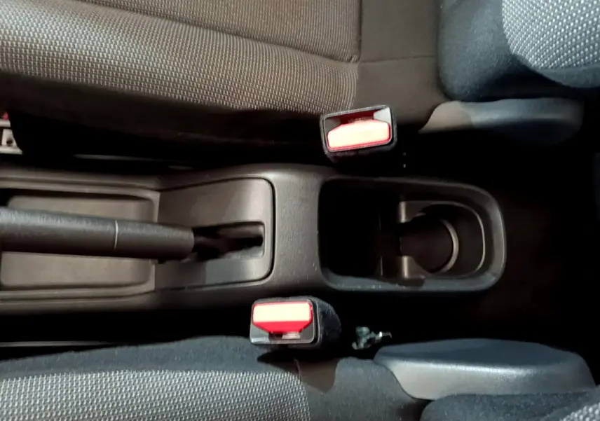 Vue plongeante sur la console centrale noire de la Citroën C3 2018, montrant frein à main et ceintures de sécurité rouges.